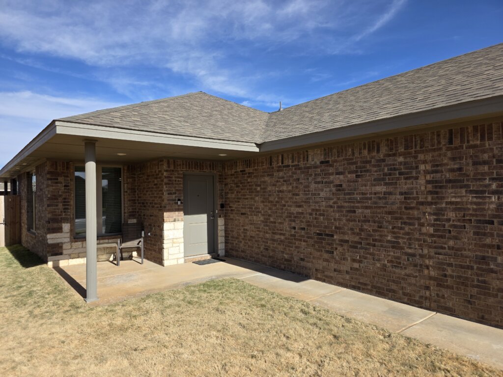 Single-story brick house with covered front porch in Lubbock, Texas, property purchased by Electrum Properties.