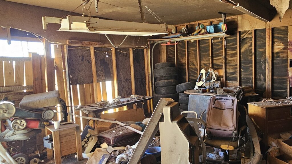 Cluttered Hoarder House Garage In Lubbock Texas With Broken Furniture, Trash, And Piles Of Belongings Left Behind, Showing That Cash Home Buyers Purchase Properties As-Is And Help Homeowners Sell Your House Fast For Cash Without Cleaning Or Repairs