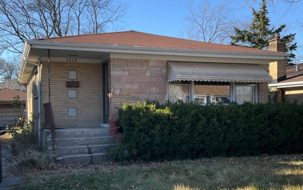 Outdated exterior of inherited home in Chicago suburbs filled with personal belongings.