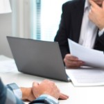 disadvantage of selling to an investor over a traditional buyer | businessperson on laptop