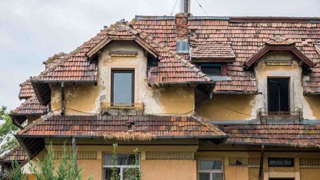 A dilapidated house with crumbling walls and a sagging roof