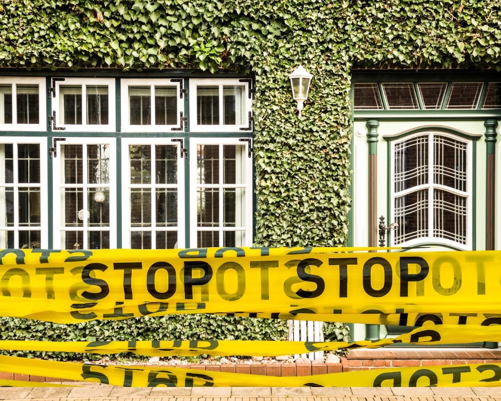 Condemned house surrounded by safety tape to signify hazard areas needing immediate attention