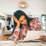 A first-time home seller stressed while looking at documents and planning to avoid common mistakes.