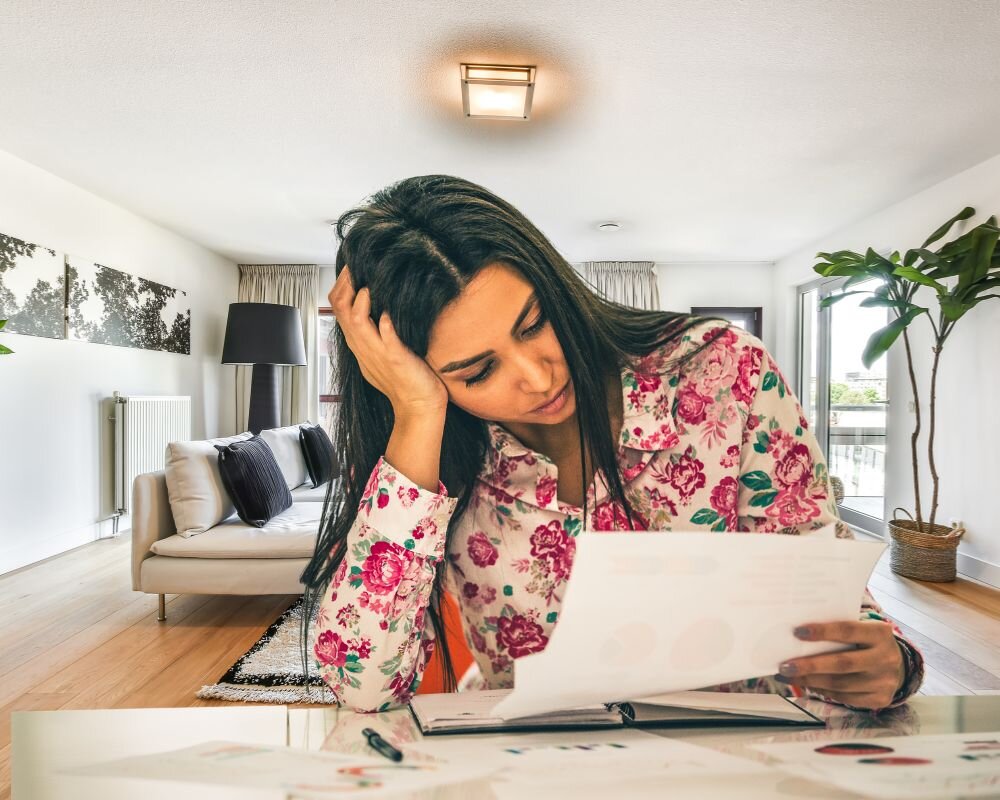 A first-time home seller stressed while looking at documents and planning to avoid common mistakes.