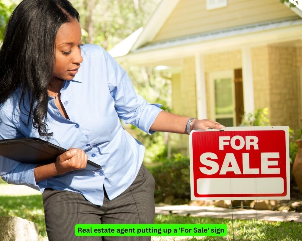 Real estate agent placing a For Sale sign in front of a foreclosed home