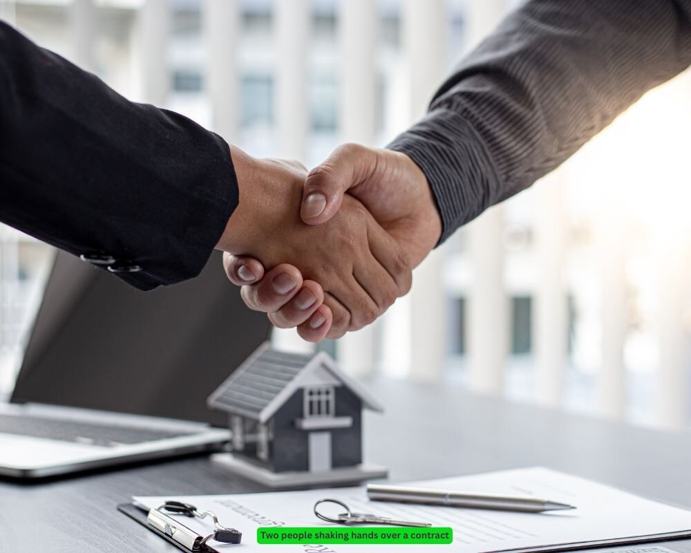 two people negotiating and shaking hands over a real estate contract