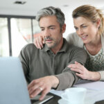 couple researching their homes market value in the internet