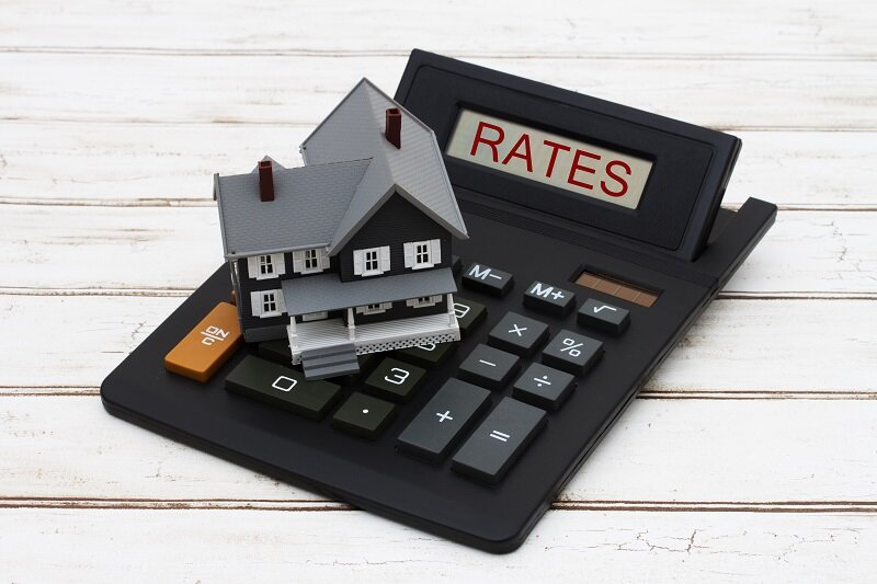A model-size house and a calculator with the word “rate”.