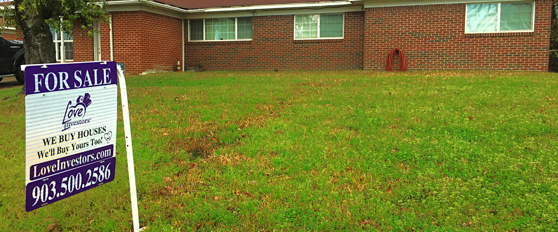 Expired listing house in Texas with a for sale sign in the front yard