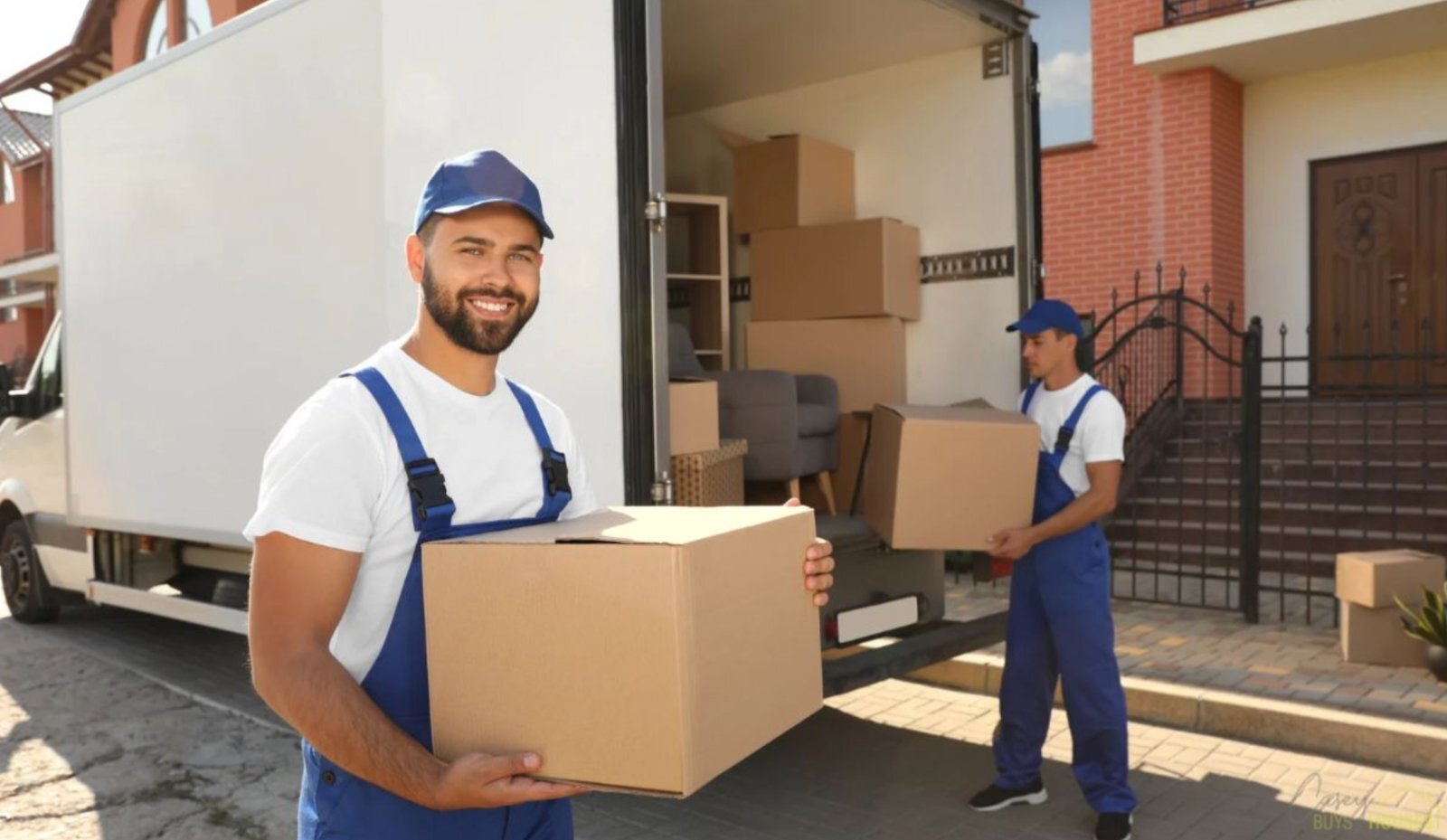 Clear-out crew loading boxes into a truck outside a home