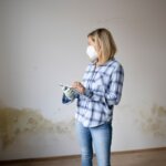 woman with mask standing in moldy house