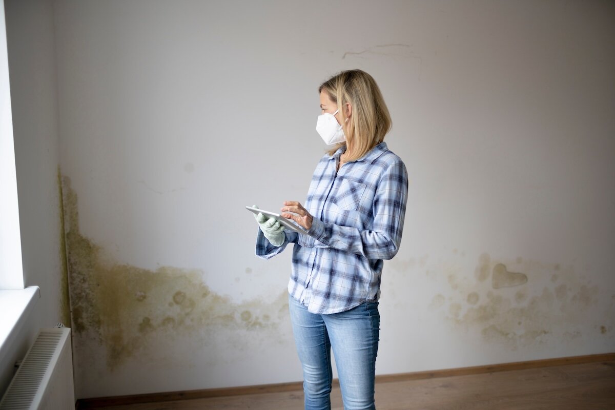 woman with mask standing in moldy house