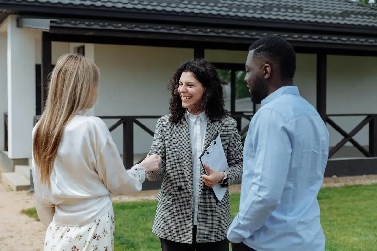 realtor shaking hands with couple