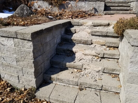 Crumbling concrete steps leading to the front door of an Anna Buys Houses rehab project.