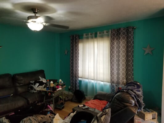 Living room filled with stuff before being cleaned out and remodeled.