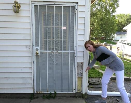 Mary Craig with Anna Buys Houses points to missing siding on a house prior to rehab.