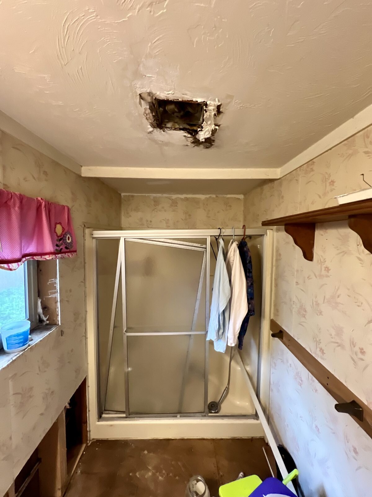 Bathroom shower area with a damaged ceiling in the Albany manufactured home