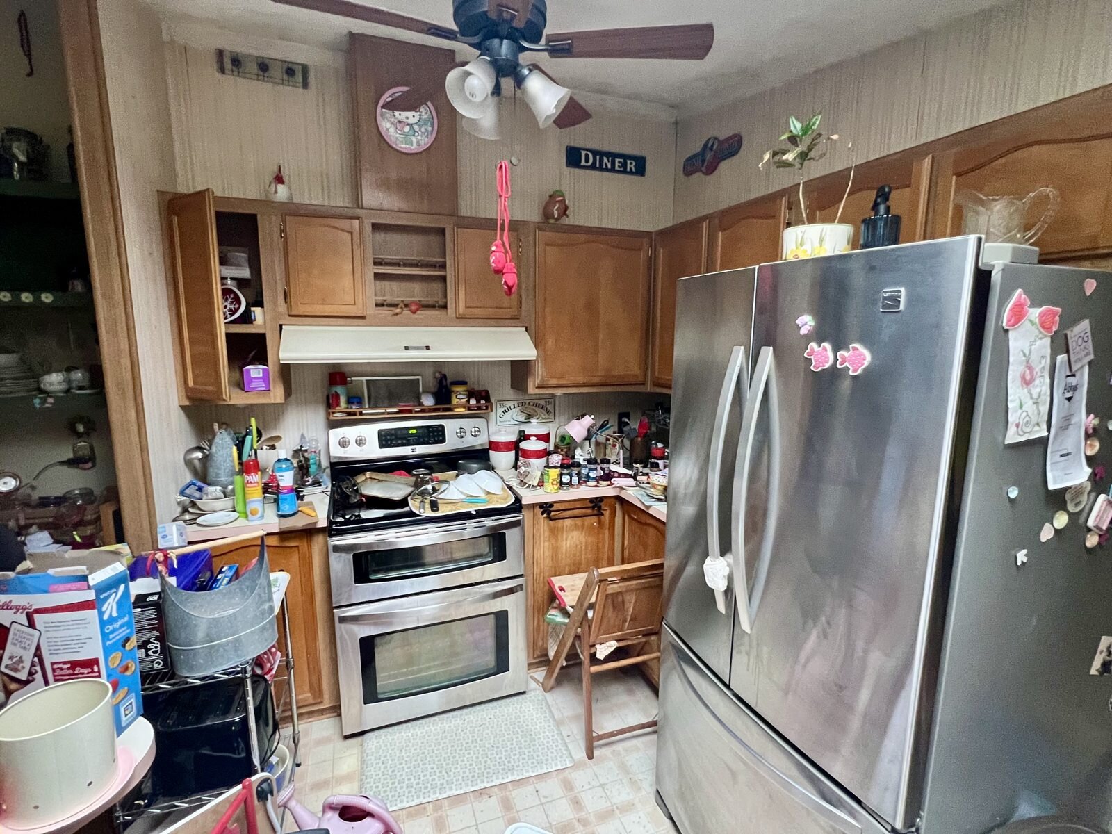 Kitchen with stainless steel appliances in the Albany manufactured home, full of the seller's belongings