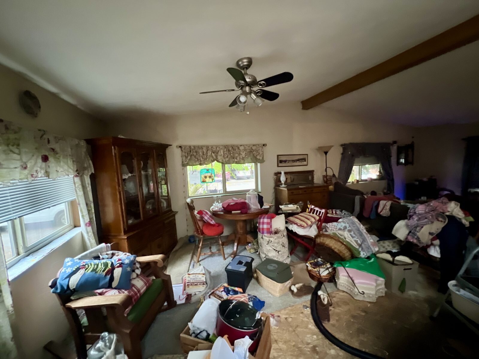 Living and dining area of the Albany manufactured home, full of the seller's furniture and belongings