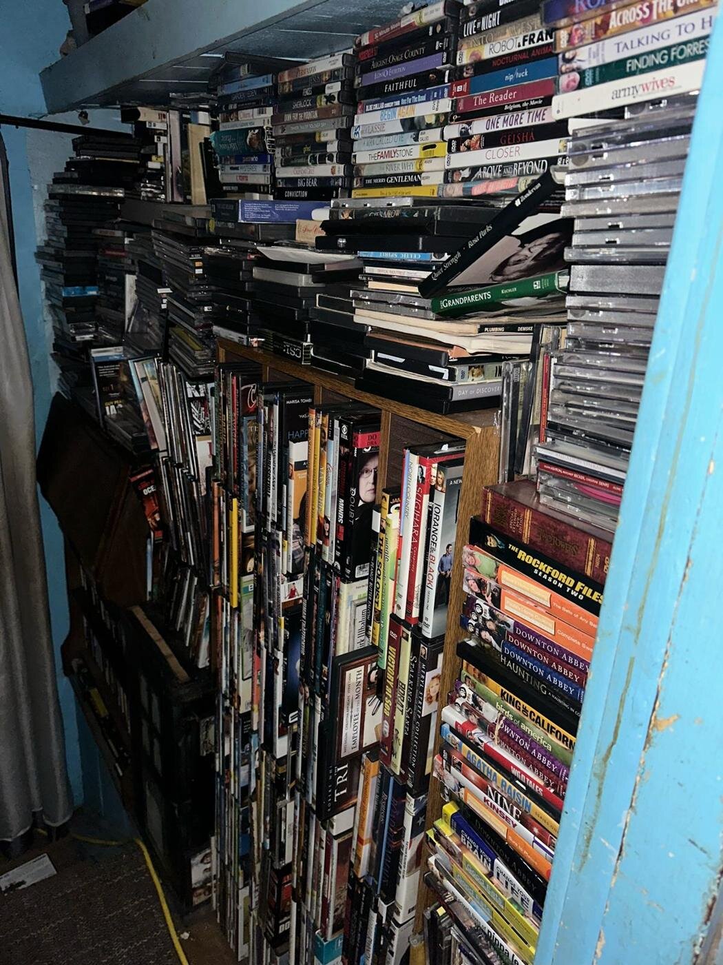Narrow room packed with shelves of books and videos