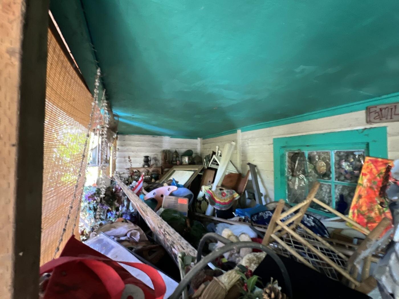 Covered porch of the Craftsman house full of furniture and belongings