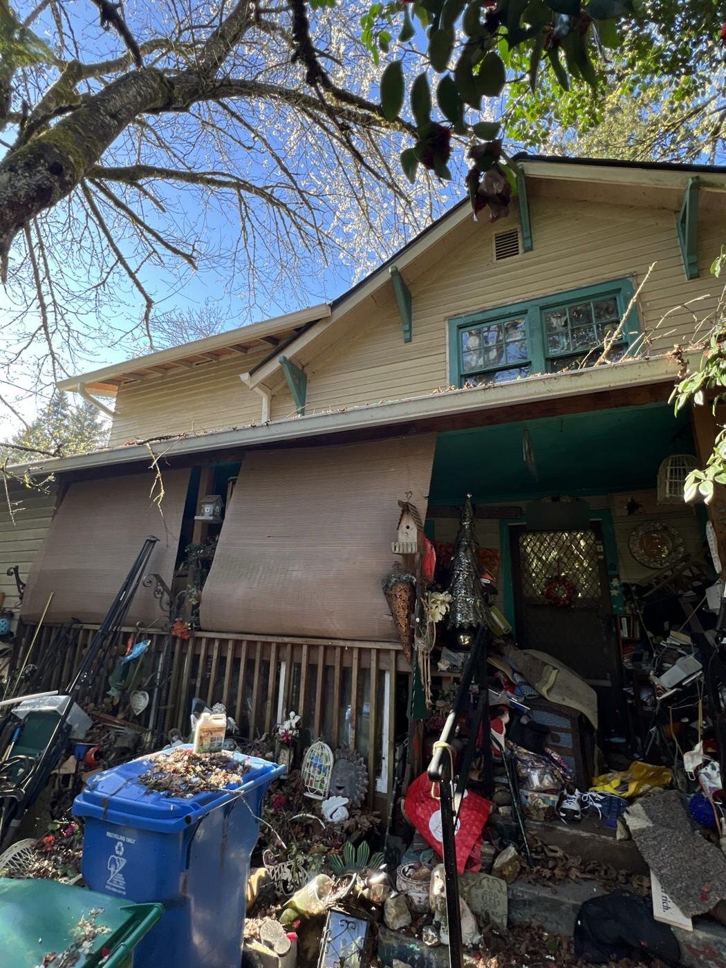 Front of the Craftsman house in Milwaukie with the porch and yard full of belongings