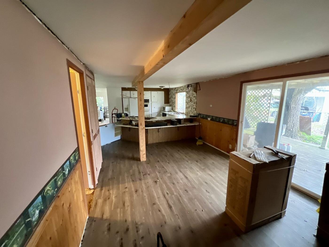 Dining and kitchen area with a wood-look floor and a pass-through counter