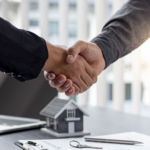 A handshake over a real estate deal, symbolizing a successful transaction, with focus on the closing costs for real estate agents as part of the agreement.