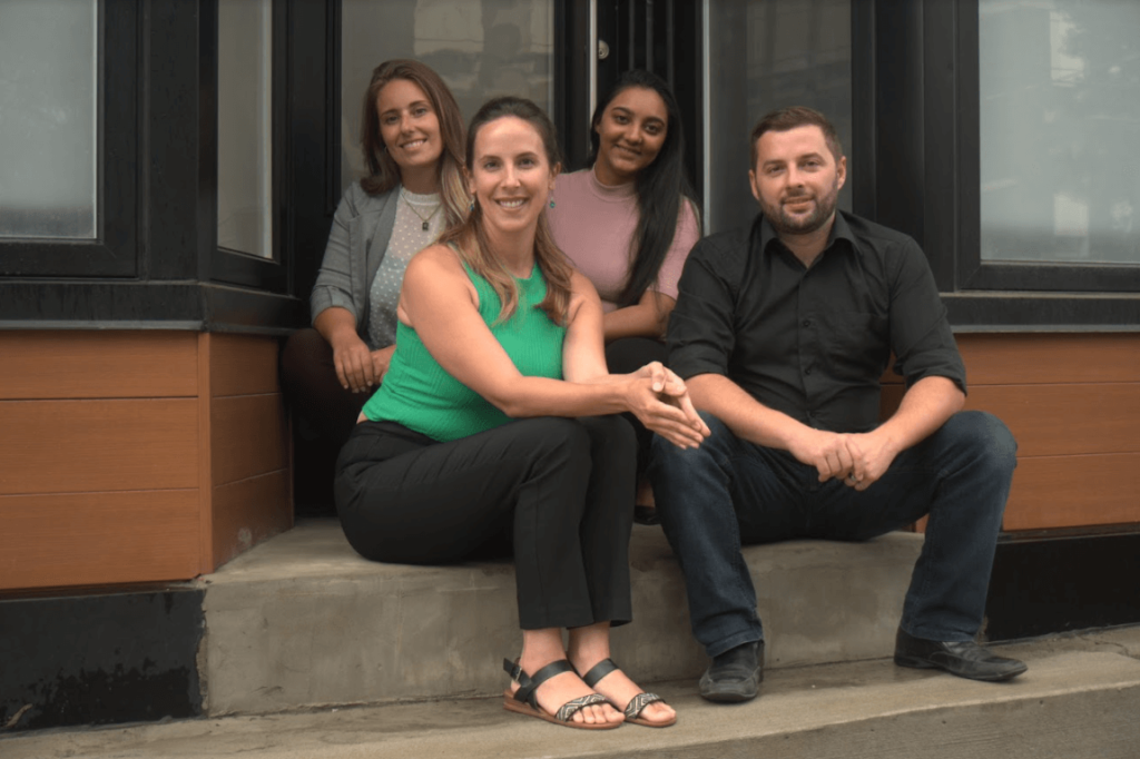 Three-women-and-one-man-sitting-in-front-of-the-door
