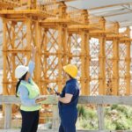 construction Workers standing in front of an ongoing construction in the background. How Do I Sell My Alabama Land To A Developer? (We Have The Answers) - We Buy Houses In Bama
