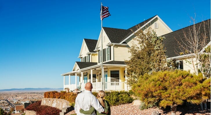 young couple standing in front of a home