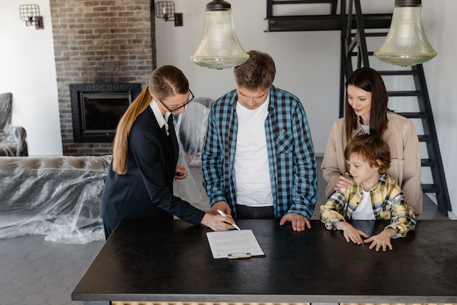 lady with family signing papers to hand over home