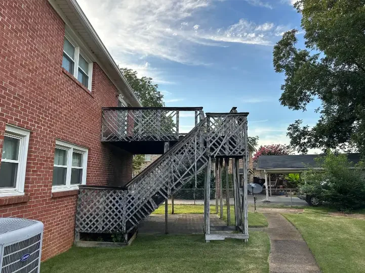 Brick house with deteriorated wooden stairs outside