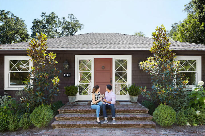 Happy couple in front of their home