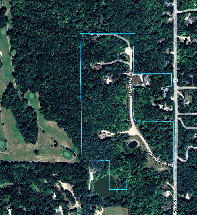 An aerial photograph of The Estates at River Valley, a prestigious single-street subdivision of custom-built single-family luxury homes located off the west side of Valley Rd in northeast Hinckley, Ohio 44233. The community is designated with a blue border around its perimeter, comprising the cul-de-sac street of River Valley Trail. Lots are heavily forested, offering wooded privacy in every direction. The Estates at River Valley homes were built beginning in 2004 with the most recent home constructed in 2022. Valleaire Golf Club borders the west side of the development.