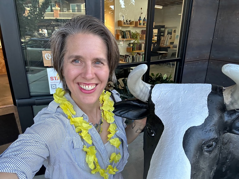 Enjoying a fun moment with a quirky cow sculpture during the Edmonds Art Walk – celebrating creativity and community.