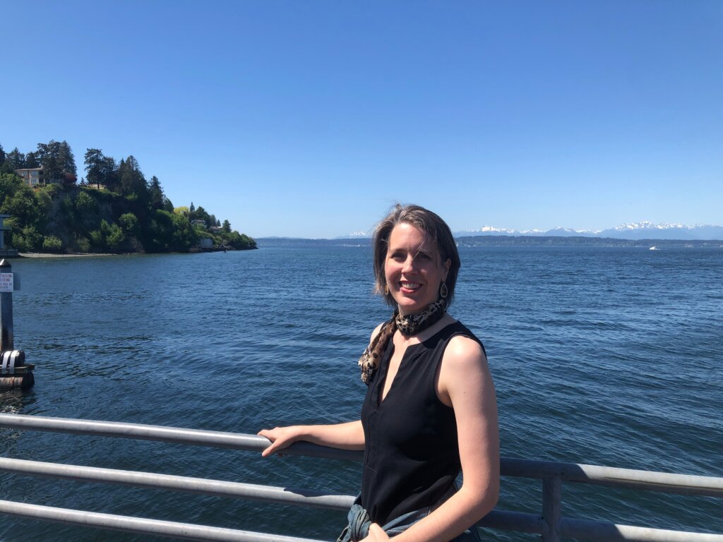 leaning against the railing of a ferry boat as it glides gracefully across the waters of Puget Sound