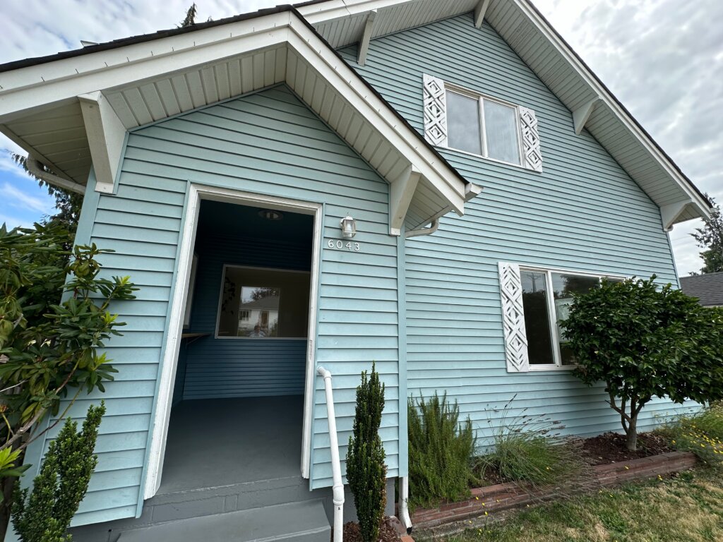 Charming light blue Craftsman home in Tacoma with decorative shutters and welcoming front entrance.
