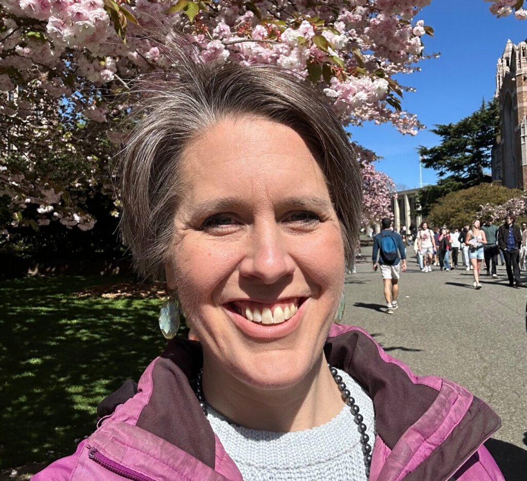 Emily Cressey smiling under cherry blossoms in Seattle