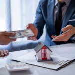 Homeowner reviewing mortgage paperwork and a cash offer for a Greensboro house