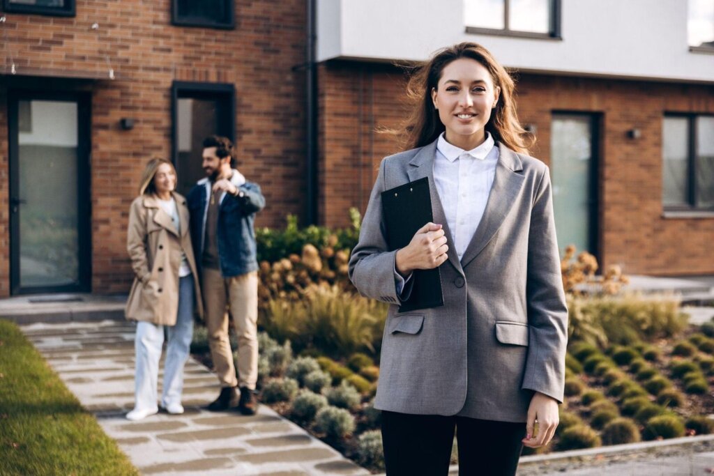 Realtor standing outside a Greensboro home with sellers, comparing a cash offer to listing