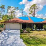 Florida home with blue tarps covering a storm-damaged roof before an as-is sale