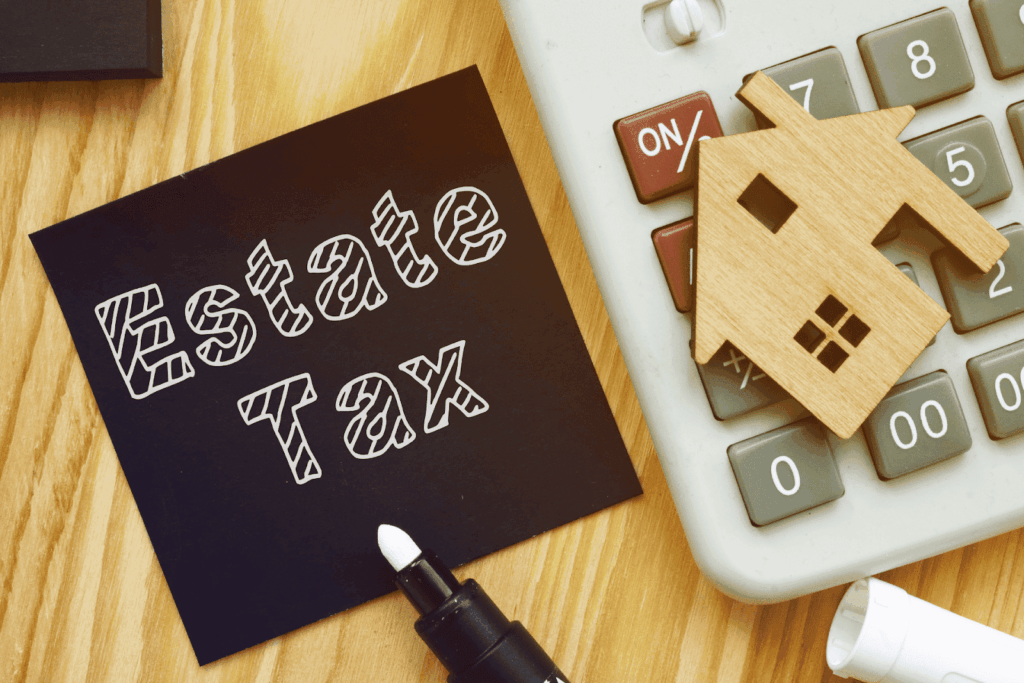 Estate Tax note beside calculator and small wooden house model.