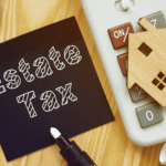 Estate Tax note beside calculator and small wooden house model.