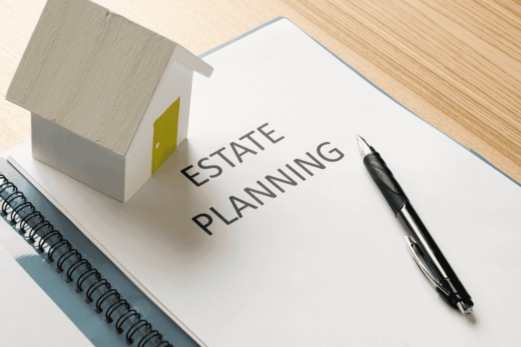 Estate planning document with pen and small house model on desk