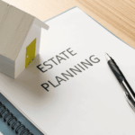 Estate planning document with pen and small house model on desk