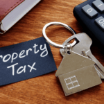 House-shaped keychain beside a note reading Property Tax and a calculator.