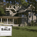 Large house with a for sale sign in the front yard.