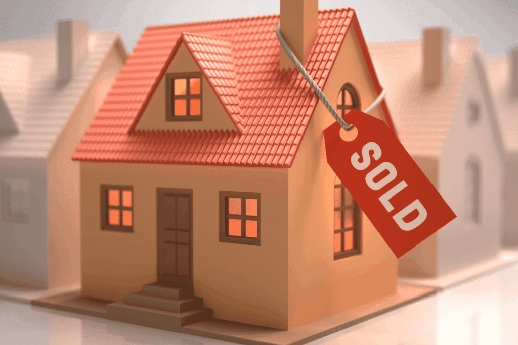 Model house with red roof and a sold tag attached