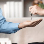 Person handing over house keys to another person indoors
